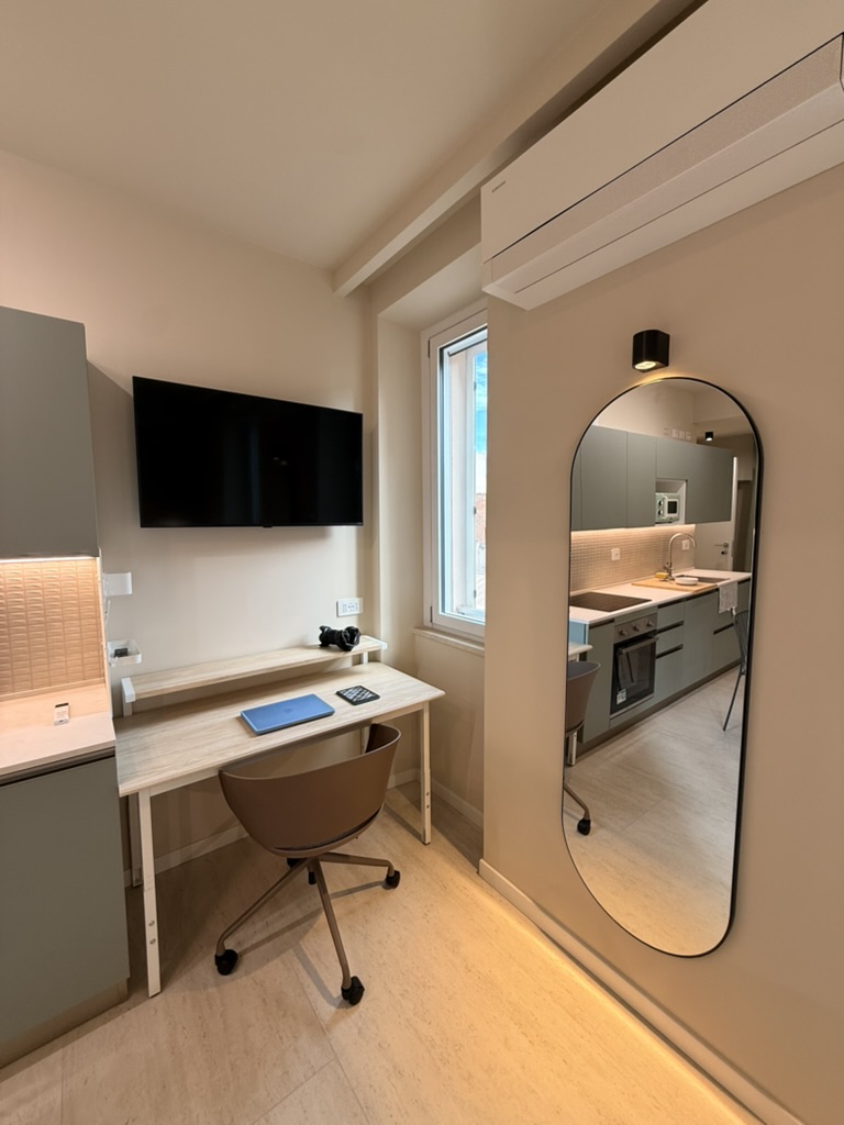 Monolocale Verde: workstation with desk, task chair and wall-mounted TV