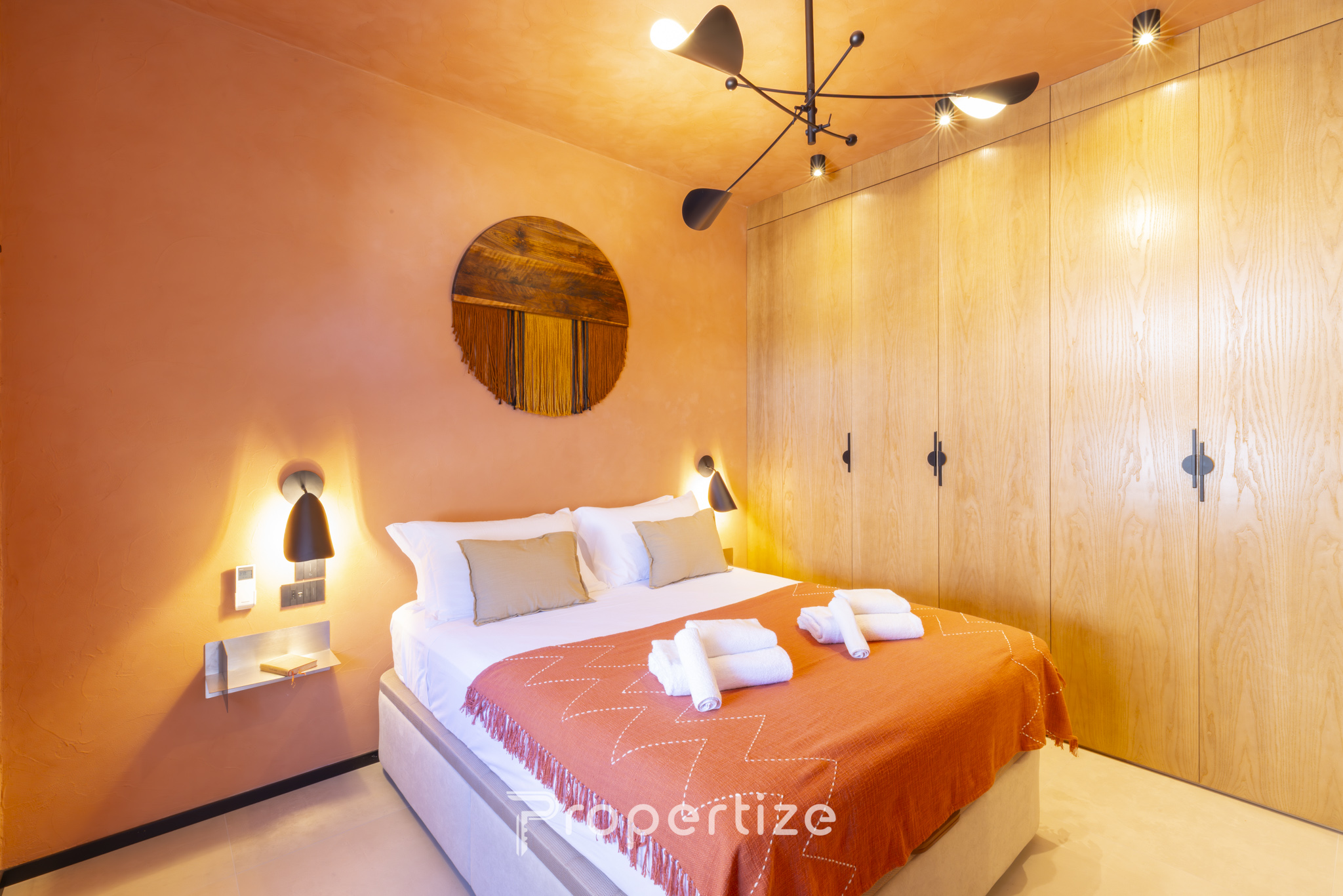 King bedroom with warm terracotta accents in Terra & Vidru Suite, Cagliari